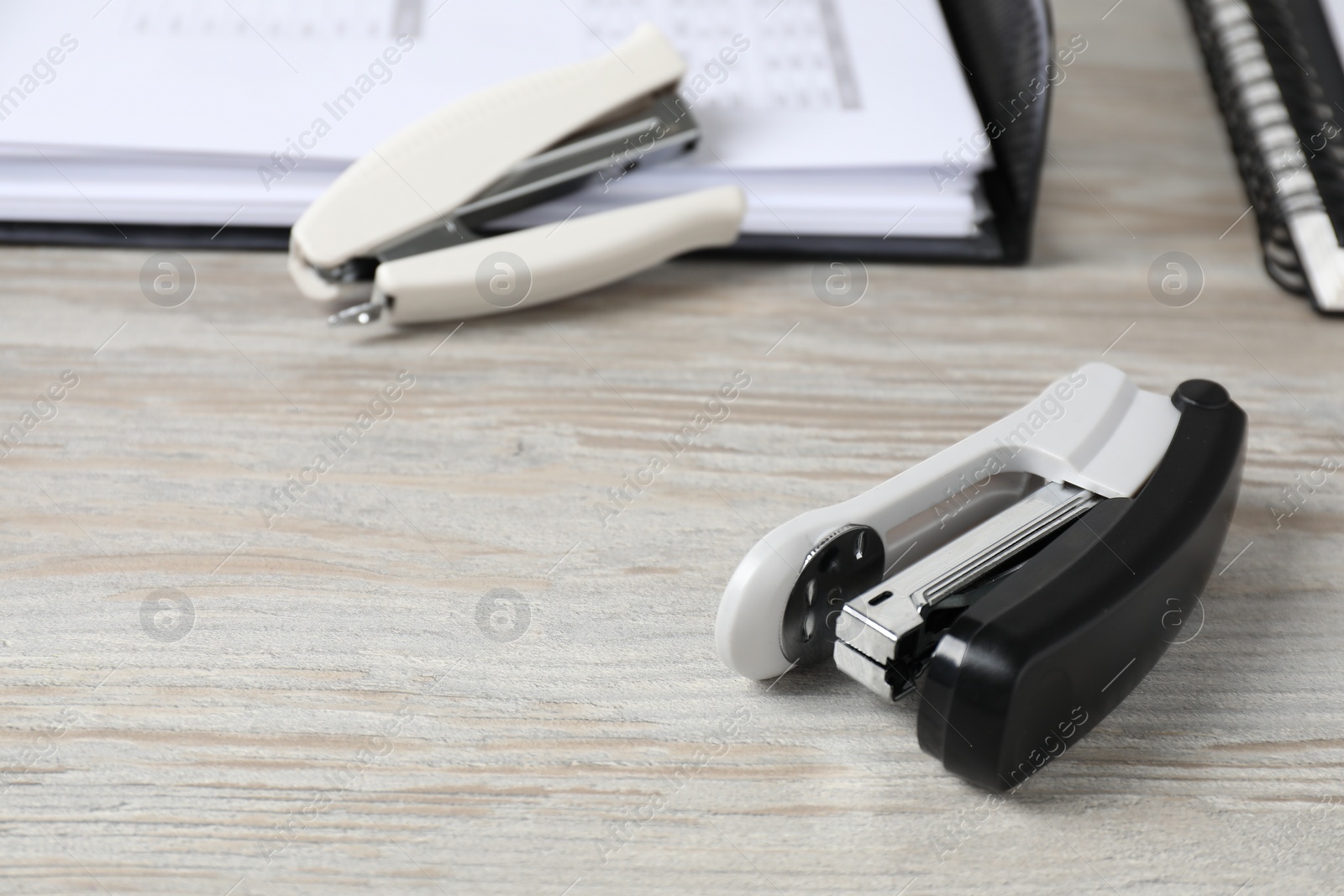 Photo of Staplers on wooden table, space for text. Office stationery