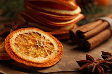 Dry orange slices, anise stars and cinnamon sticks on wooden board, closeup