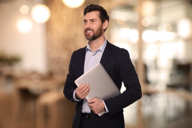 Successful lawyer with laptop on blurred background