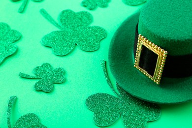 Photo of St. Patrick's day. Leprechaun hat and decorative clover leaves on green background