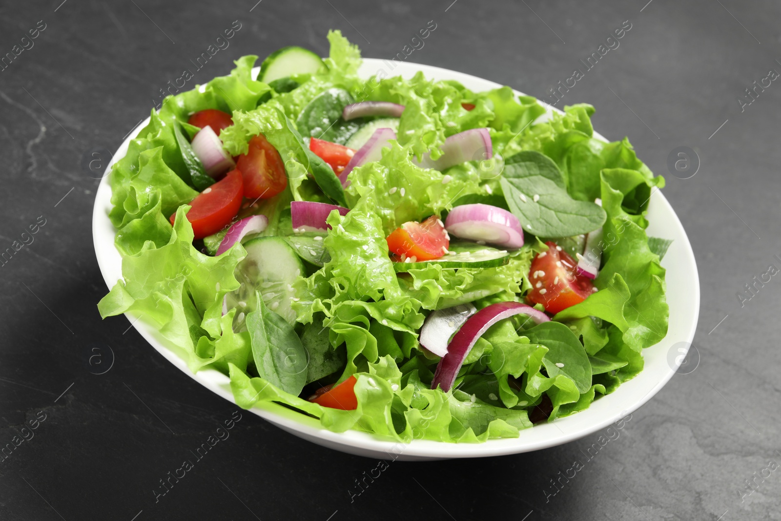 Photo of Delicious salad in bowl on grey table, closeup
