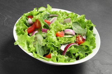 Delicious salad in bowl on grey table, closeup