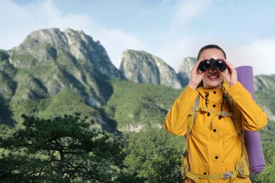 Image of Tourist with backpack and binoculars in mountains