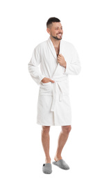 Handsome man wearing bathrobe on white background