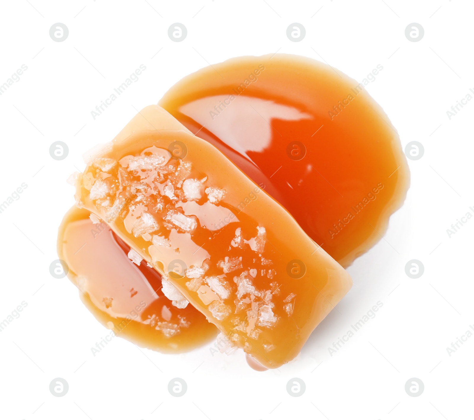 Photo of Yummy caramel candy and sea salt isolated on white, top view