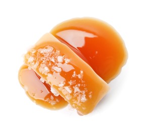 Photo of Yummy caramel candy and sea salt isolated on white, top view