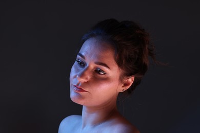 Photo of Portrait of beautiful young woman on dark background