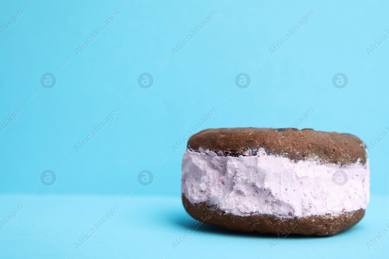 Photo of Sweet delicious ice cream cookie sandwich on color background, space for text