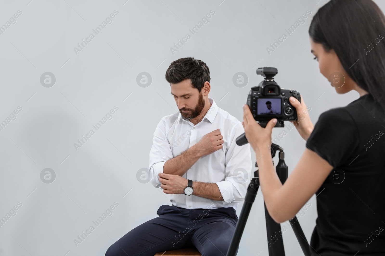 Photo of Handsome model posing for professional photographer in studio