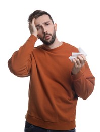 Man with tissue suffering from cold on white background