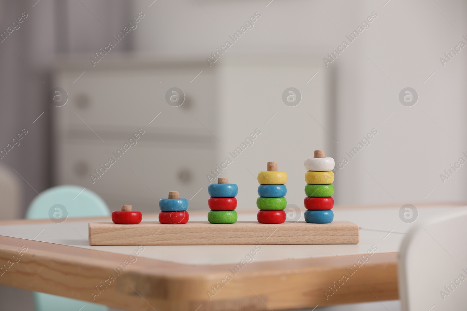 Photo of Stacking and counting game wooden pieces on table indoors, space for text. Educational toy for motor skills development