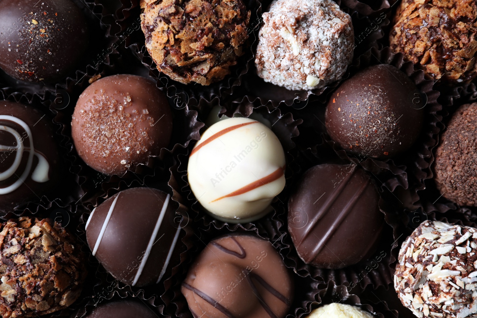 Photo of Different tasty chocolate candies as background, top view