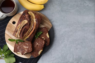 Photo of Delicious banana bread served on grey table, flat lay. Space for text