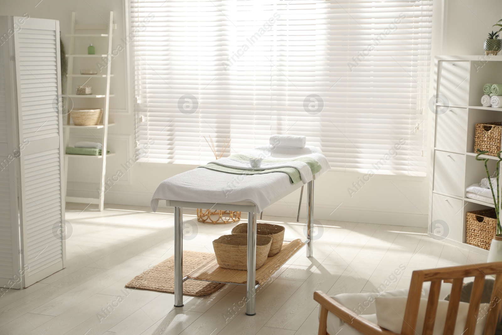 Photo of Stylish spa salon interior with massage table