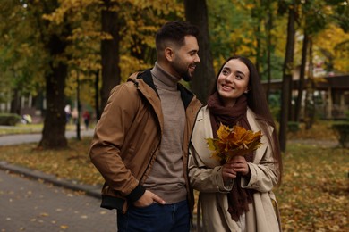 Photo of Happy young couple spending time together in autumn park