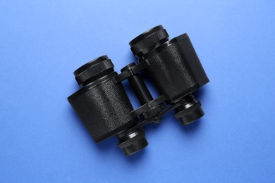 Modern binoculars on blue background, top view