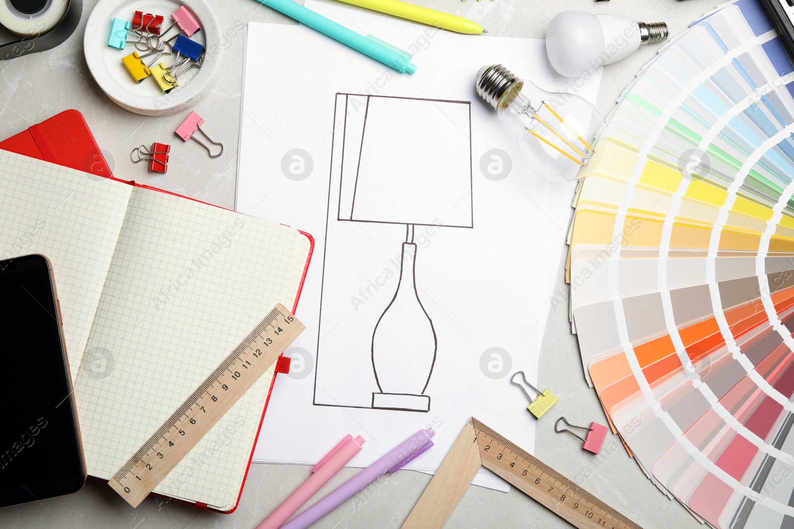 Photo of Flat lay composition with drawing of lamp on light grey table. Designer's workplace