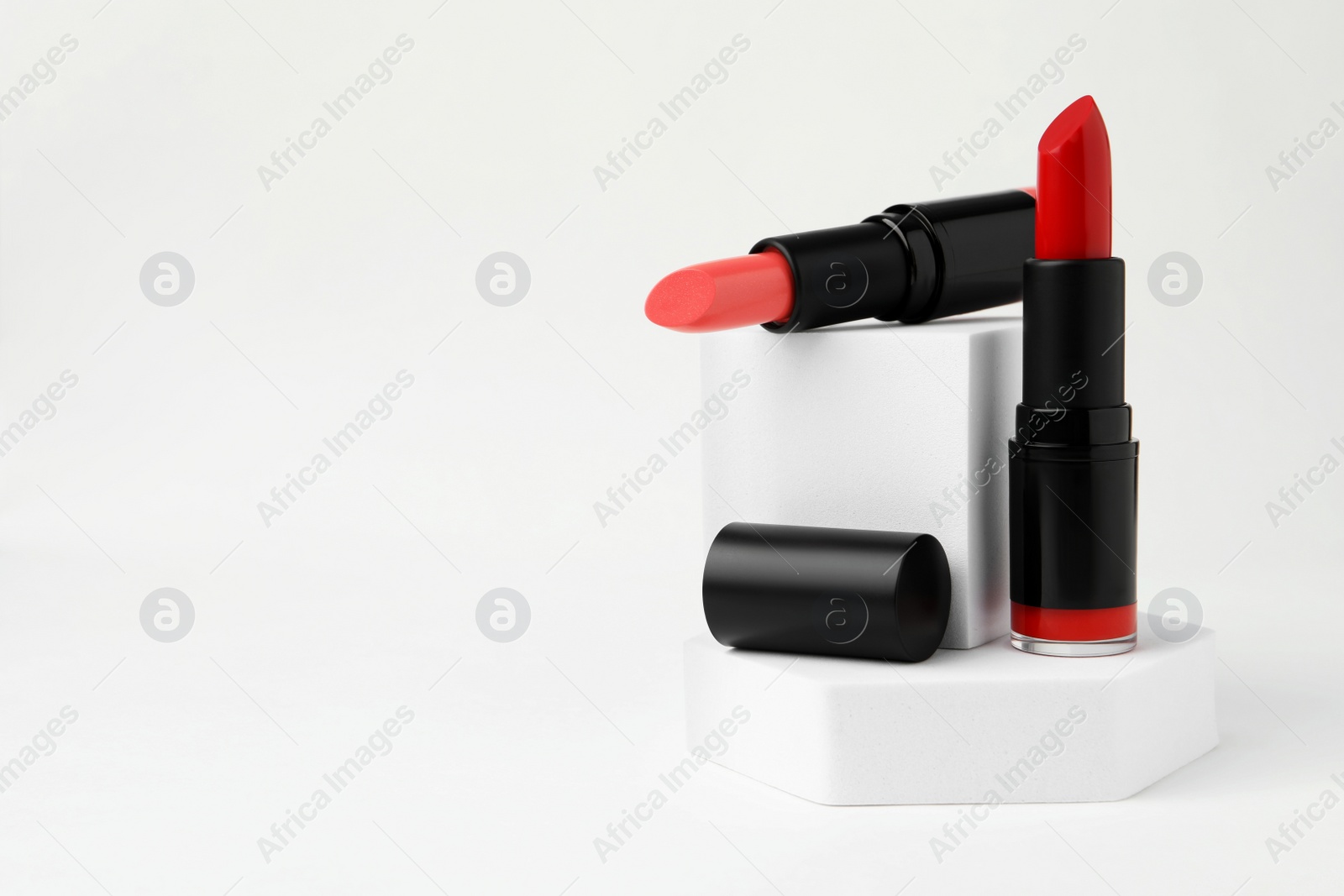 Photo of Different beautiful glossy lipsticks on white background, space for text