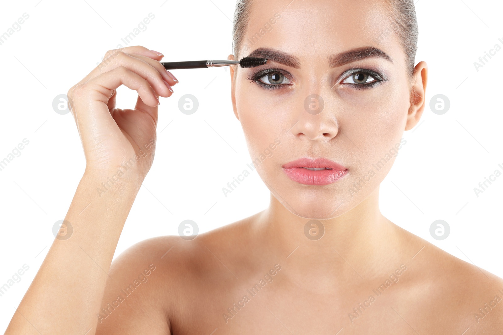 Photo of Portrait of beautiful woman applying stylish makeup with brush on white background