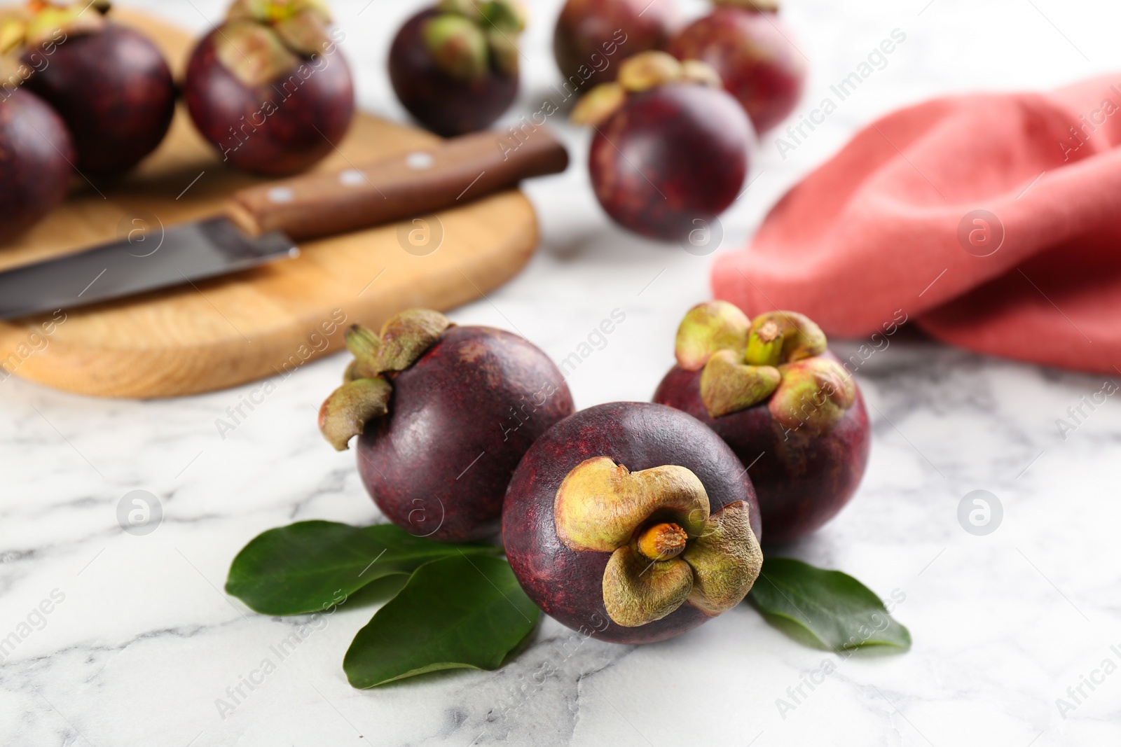 Photo of Fresh ripe mangosteen fruits on white marble table