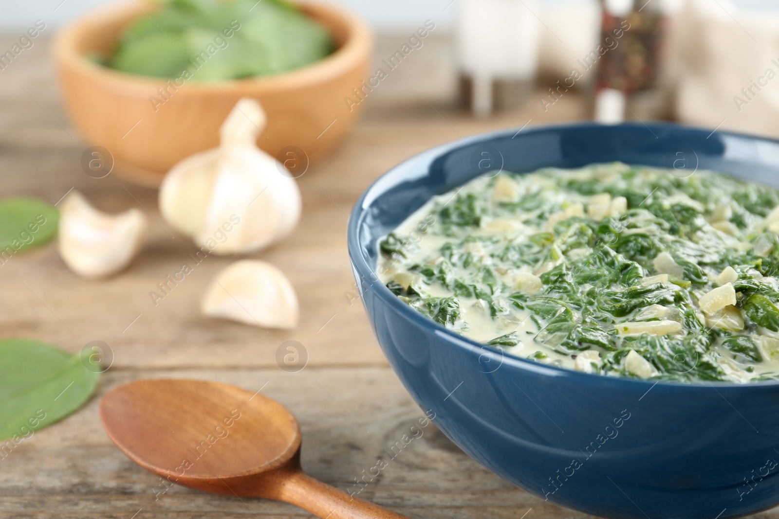 Photo of Tasty spinach dip in bowl on wooden table