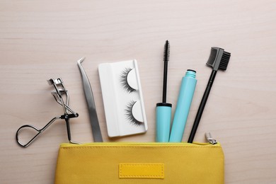 Flat lay composition with false eyelashes and tools on wooden table