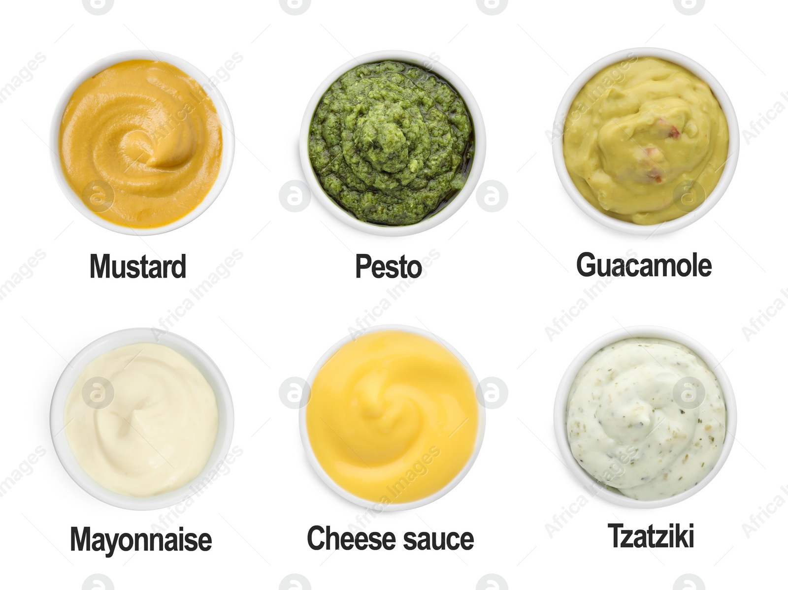 Image of Set of different sauces in bowls and names isolated on white, top view