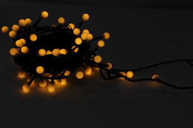 Photo of Beautiful glowing Christmas lights on dark background