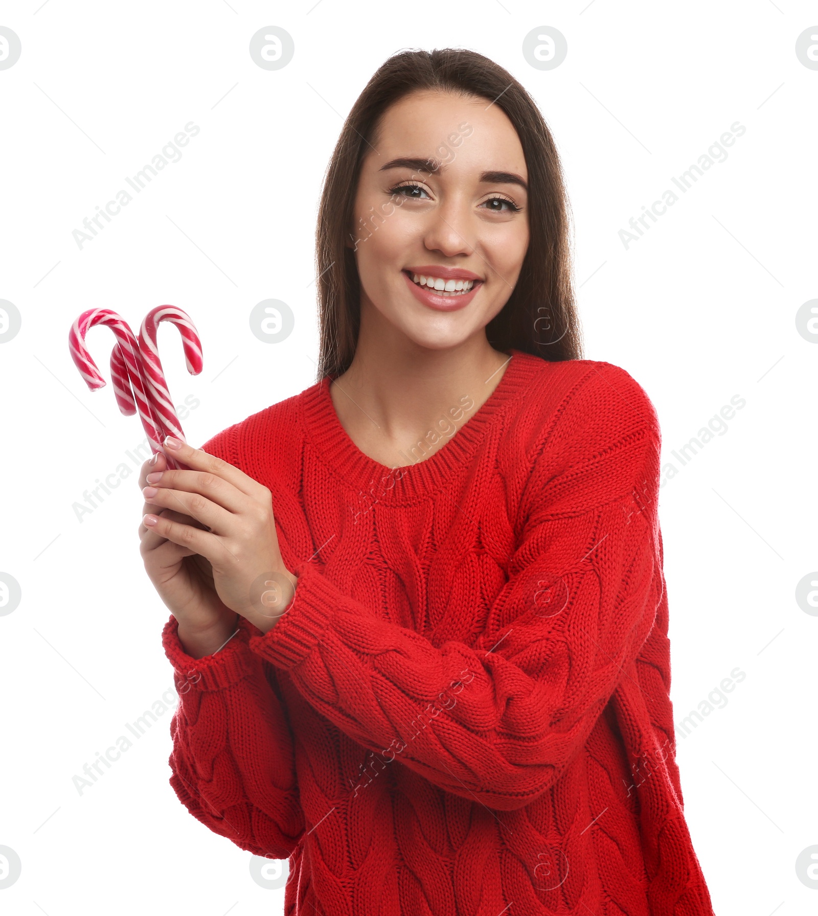 Photo of Young woman in red sweater holding candy canes on white background