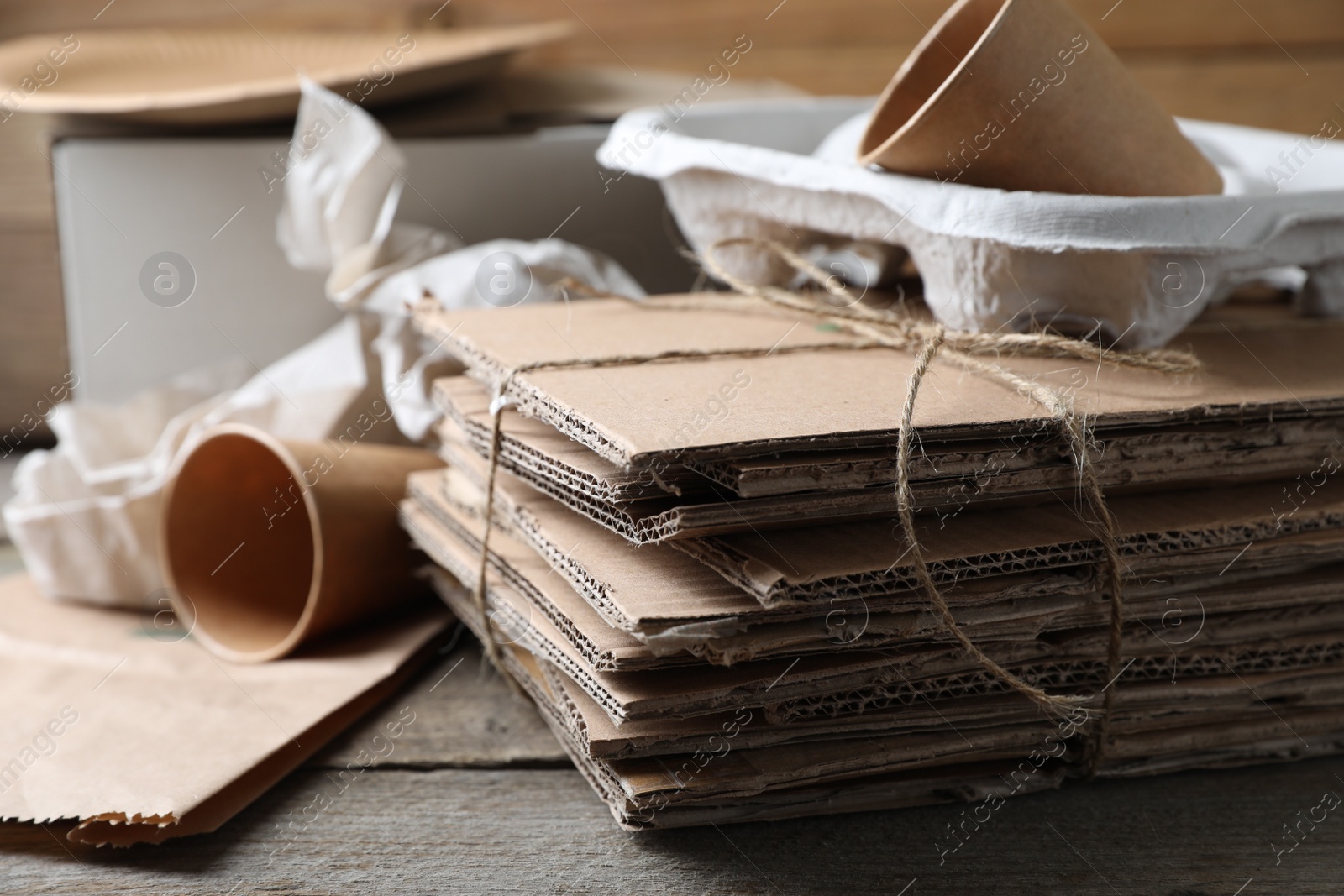 Photo of Different waste paper on wooden table, closeup. Space for text