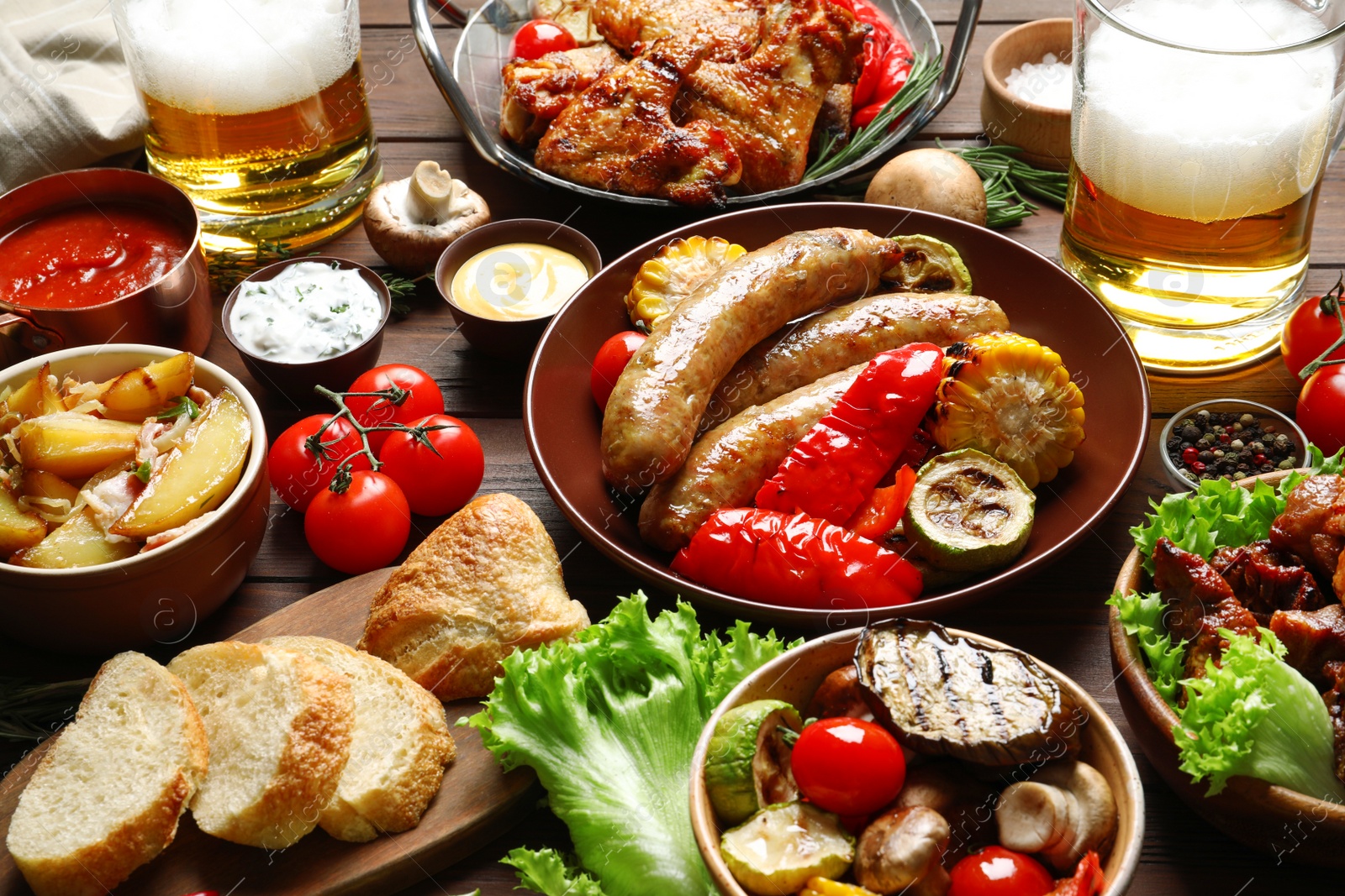 Photo of Delicious meal served for barbecue party on wooden table