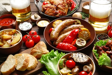 Photo of Delicious meal served for barbecue party on wooden table