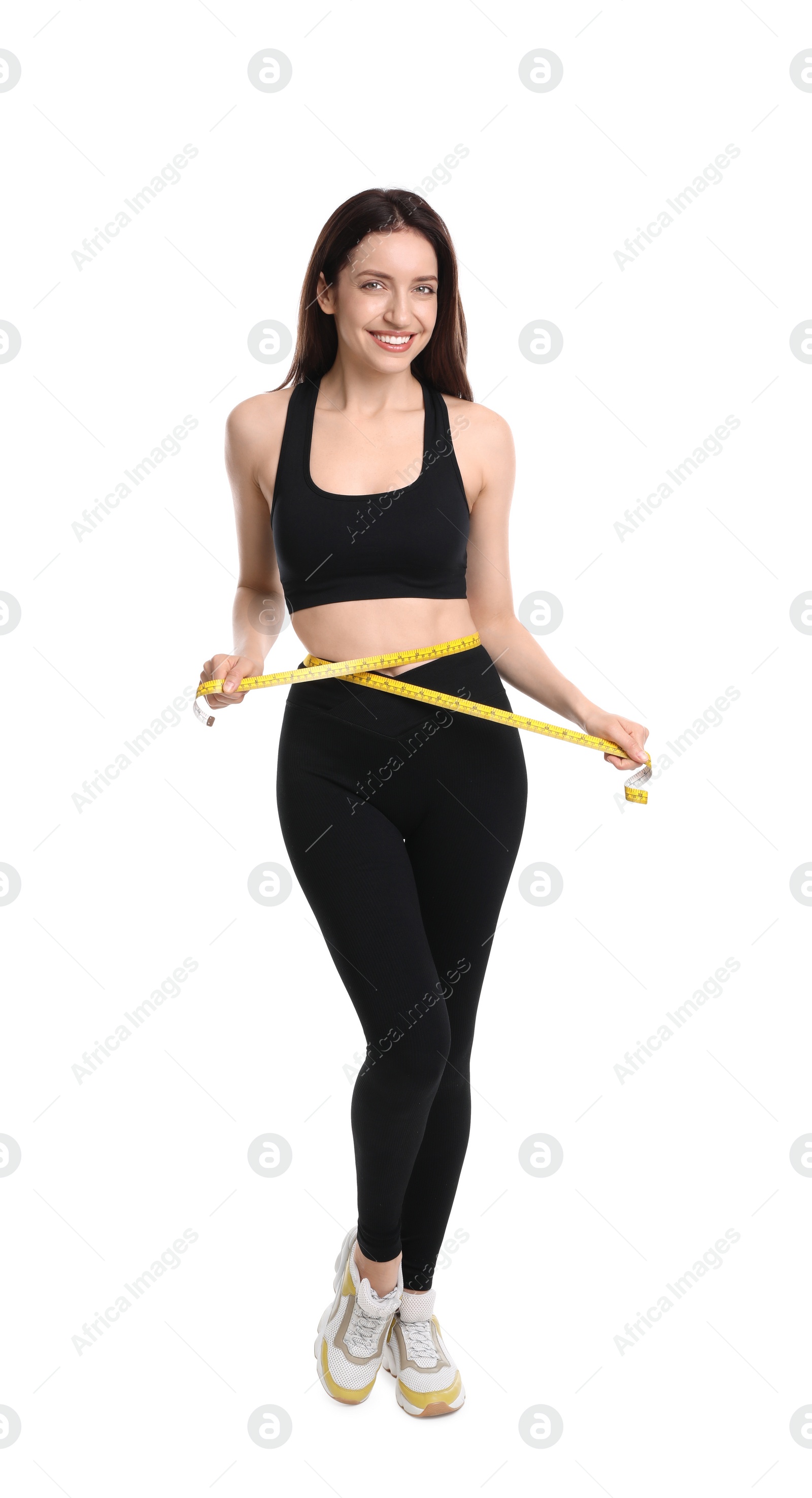 Photo of Happy young woman with measuring tape showing her slim body against white background