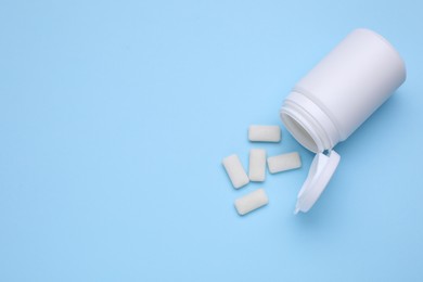 Photo of Jar with chewing gums on light blue background, flat lay. Space for text