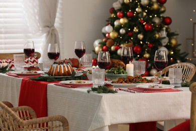 Photo of Festive dinner with delicious food and wine on table indoors. Christmas Eve celebration