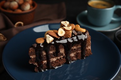 Photo of Piece of tasty homemade chocolate cake with nuts on plate, closeup