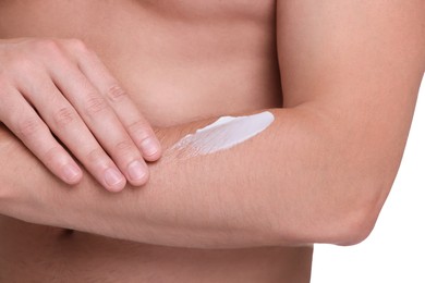 Man applying sun protection cream onto his arm against white background, closeup