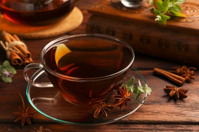 Photo of Aromatic tea with anise stars and mint on wooden table