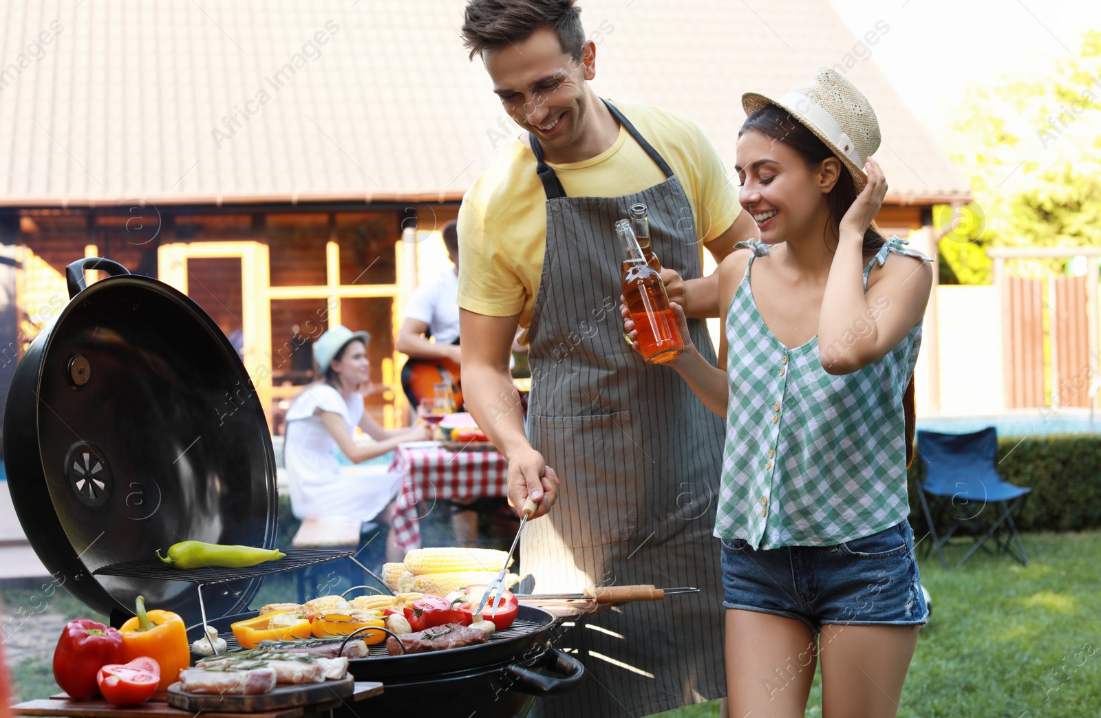 Photo of Young man and woman near barbecue grill outdoors