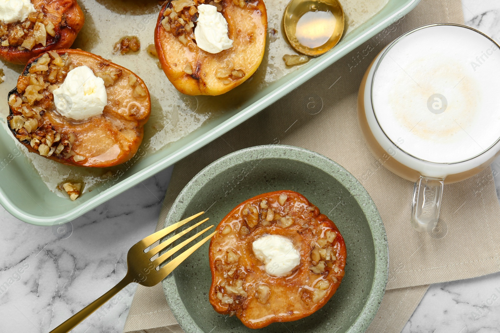 Photo of Tasty baked quinces with nuts and cream cheese served on white marble table, flat lay