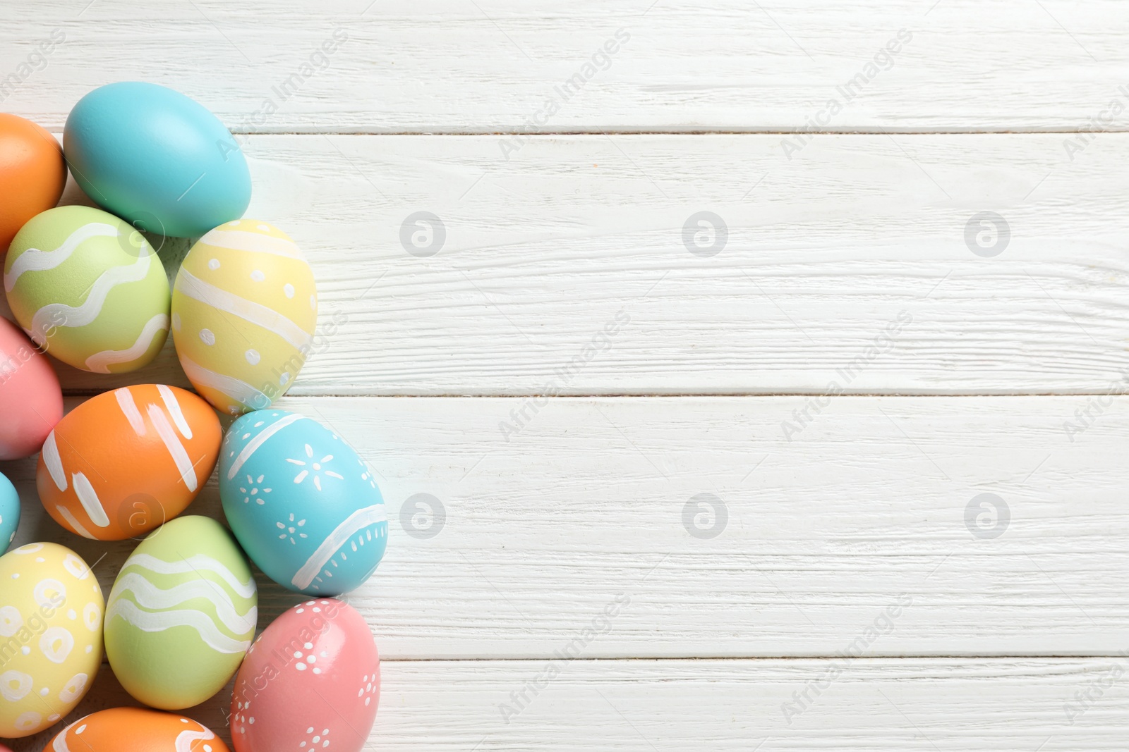 Photo of Many colorful painted Easter eggs on wooden background, top view. Space for text