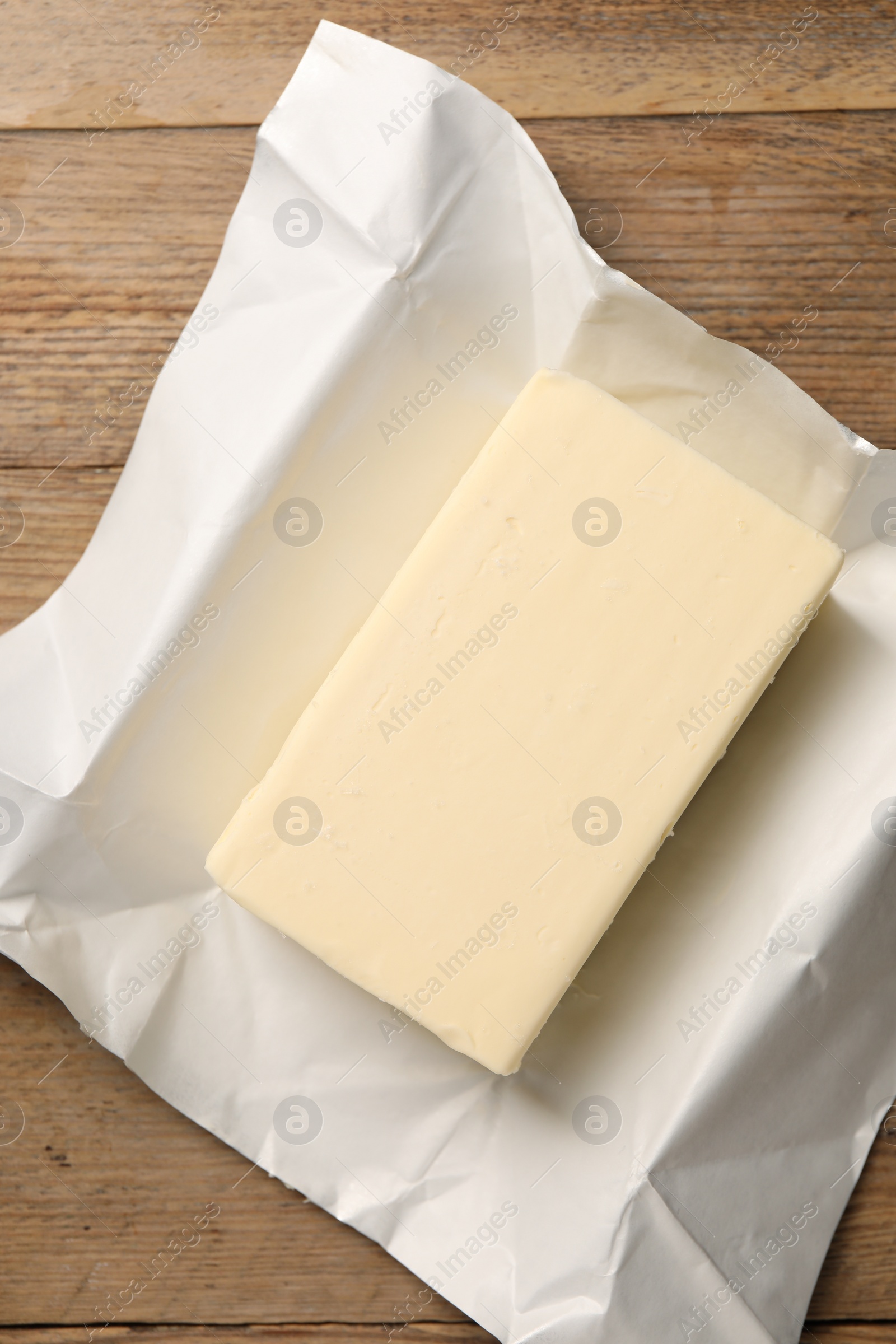 Photo of Block of tasty butter on wooden table, top view