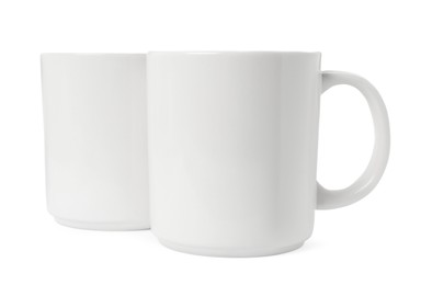 Photo of Two light ceramic mugs isolated on white