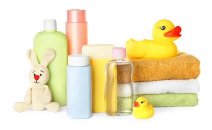 Photo of Bottles of baby cosmetic products, towels and toys on white background