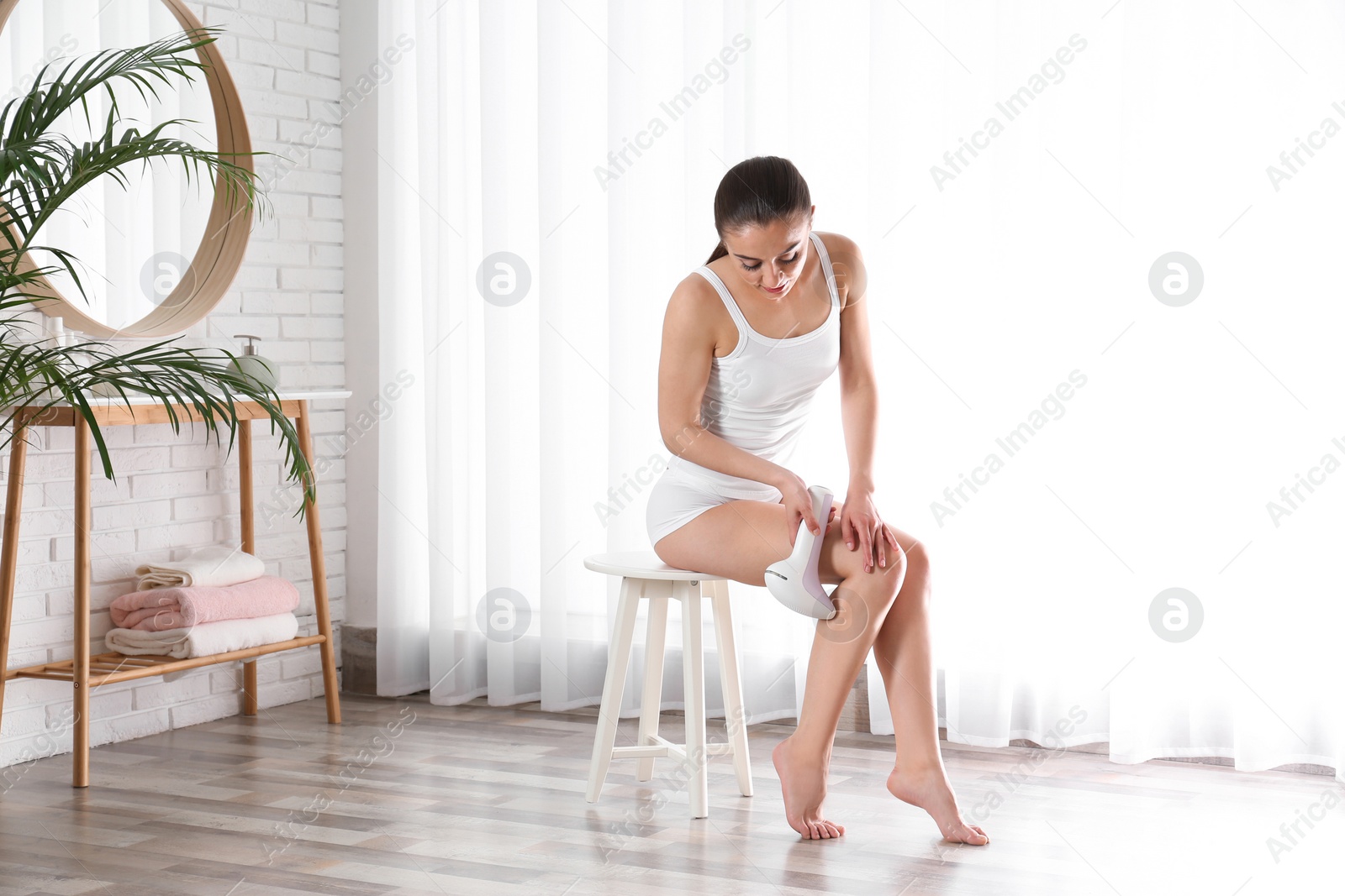 Photo of Young woman doing leg epilation procedure indoors. Space for text