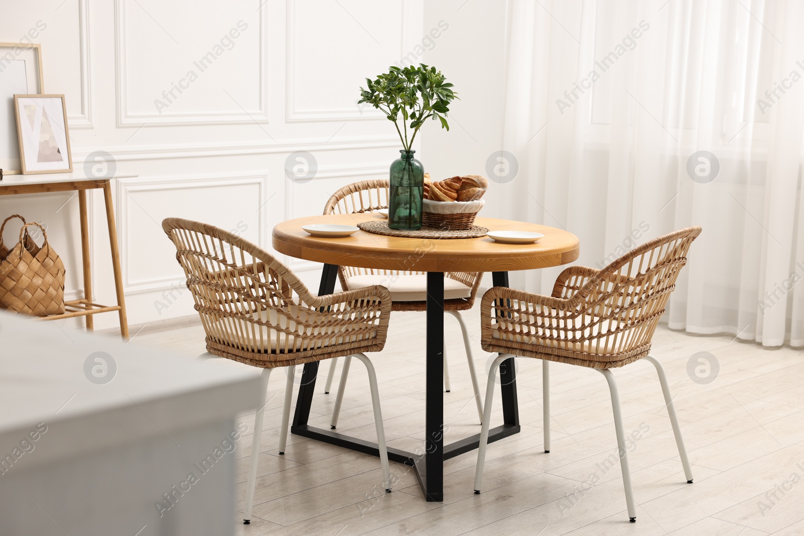 Photo of Dining room interior with comfortable furniture and green branches