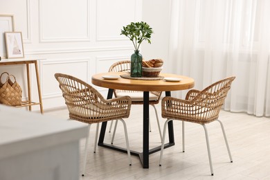 Dining room interior with comfortable furniture and green branches