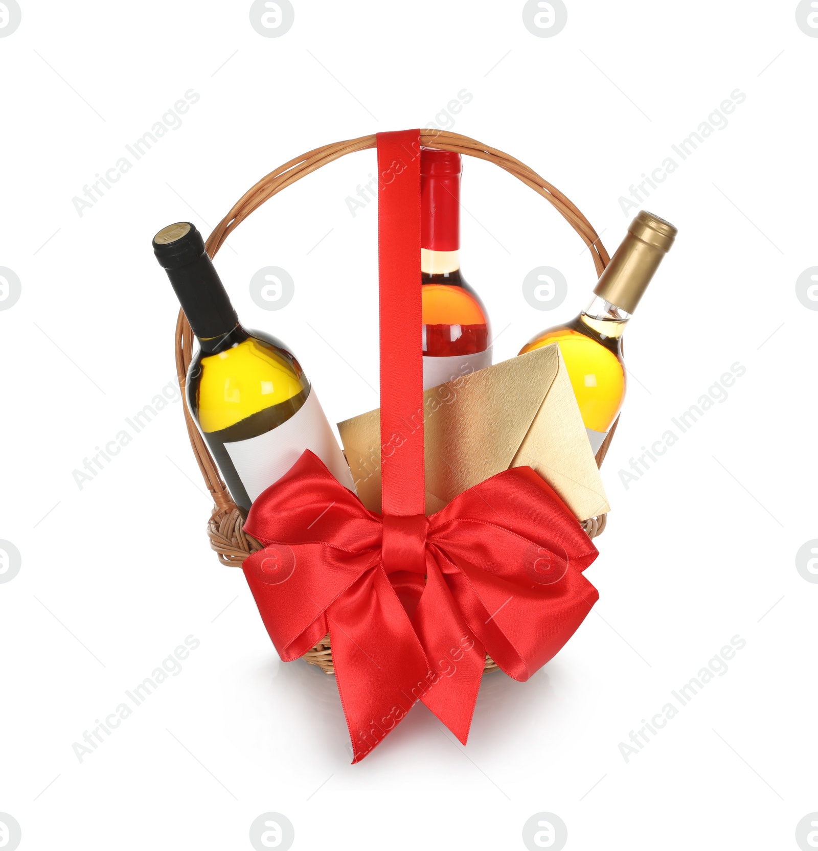 Photo of Bottles of wine and gold envelope in wicker basket with red bow isolated on white