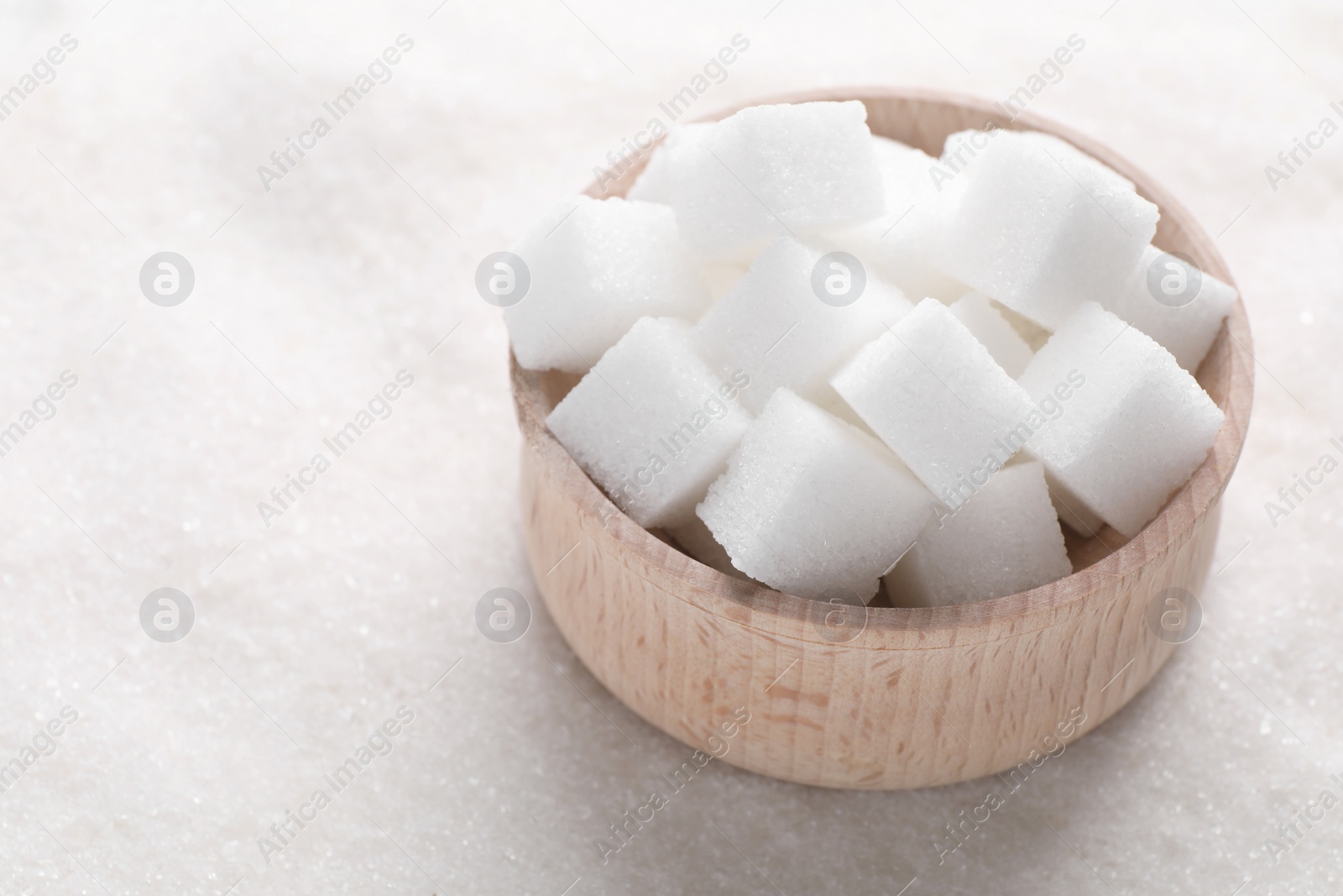 Photo of Different types of white sugar and bowl as background, closeup. Space for text