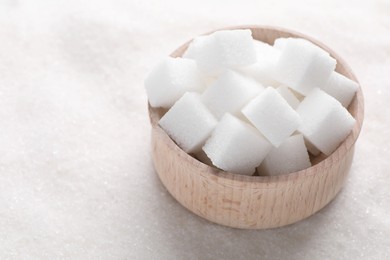 Different types of white sugar and bowl as background, closeup. Space for text